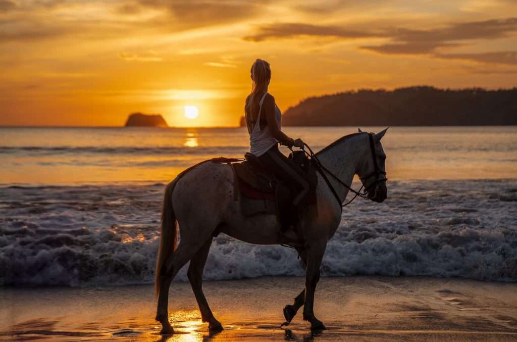 Horseback riding along Playa Carrillo beach at sunset arranged by Ventanas del Mar concierge