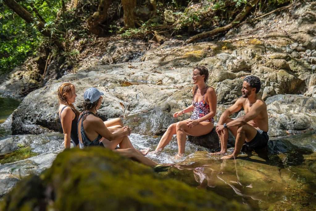 Visitors enjoying a natural waterfall swimming hole along a private hiking trail at Ventanas del Mar Guanacaste Costa Rica