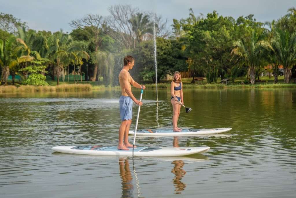 Couple paddleboarding on the freshwater lake at Ventanas del Mar Blue Zone Nicoya Peninsula wellness community