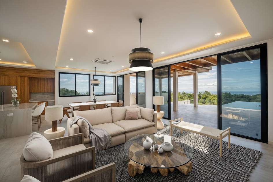 Modern open-plan living room with floor-to-ceiling windows and jungle views at a luxury home in Ventanas del Mar, Costa Rica