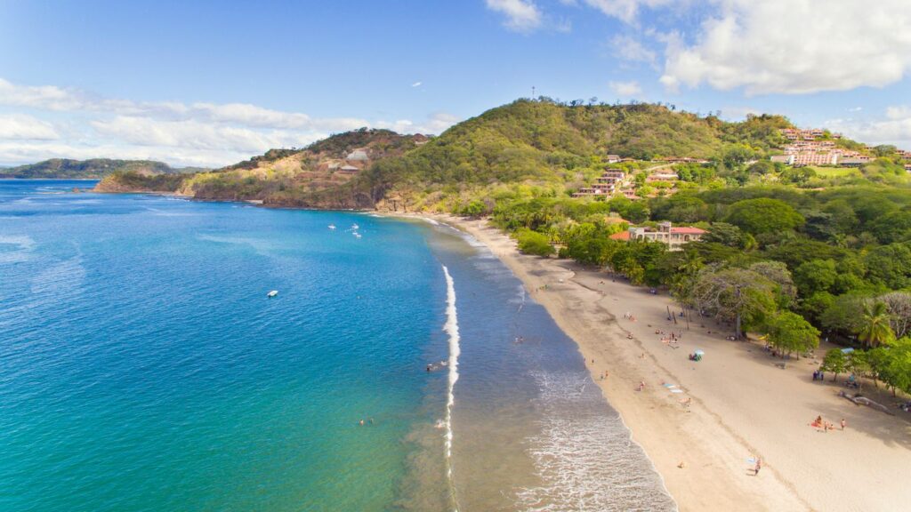 Calm, shallow golden shoreline at Playa Hermosa, Guanacaste, Costa Rica, a sheltered family-friendly swimming bay