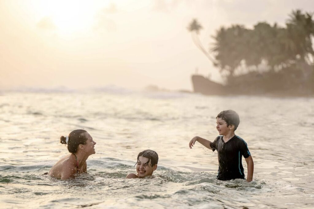 Children wading in gentle turquoise shallows on a calm white-sand beach in Guanacaste, Costa Rica